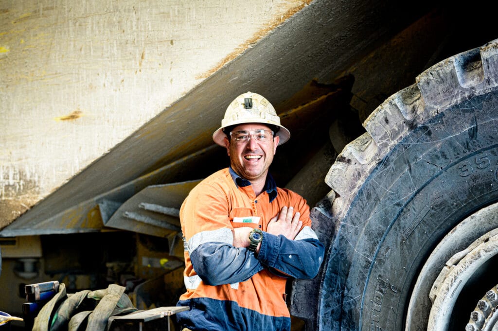 Miner with folded arms smiling